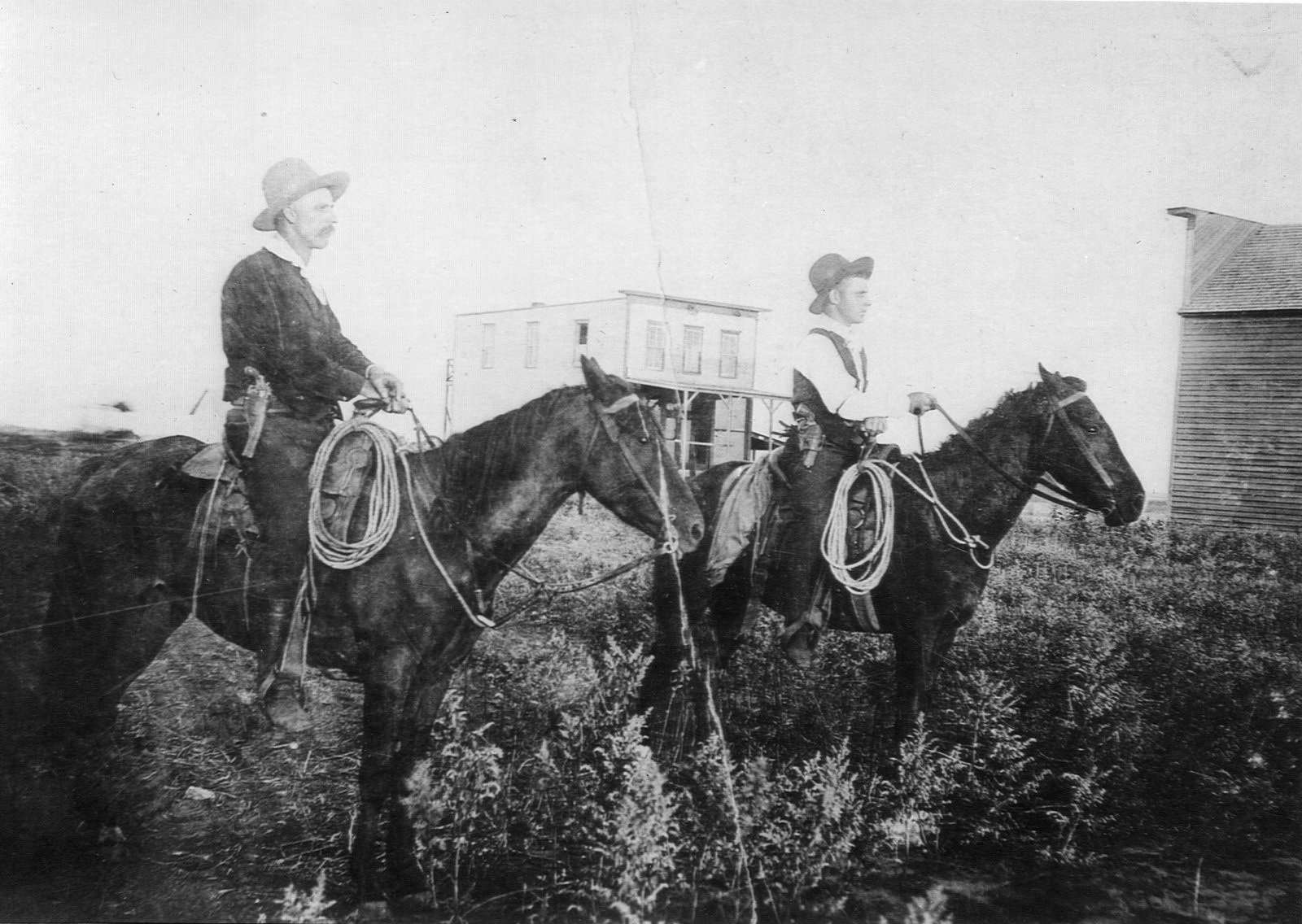 Edward Walker and his son Orville "O.G." Walker on horseback near Cayley, early 1900s